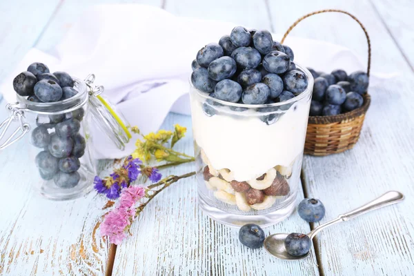 Přírodní jogurt s čerstvými borůvkami na dřevěný stůl — Stock fotografie