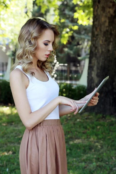 Beautiful young girl with tablet on city street — Stock Photo, Image