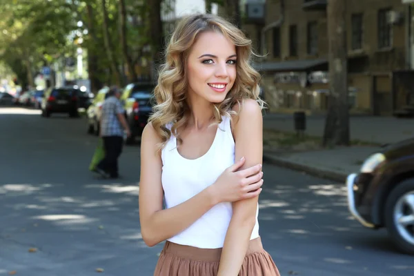 Beautiful young girl posing on city street — Stock Photo, Image