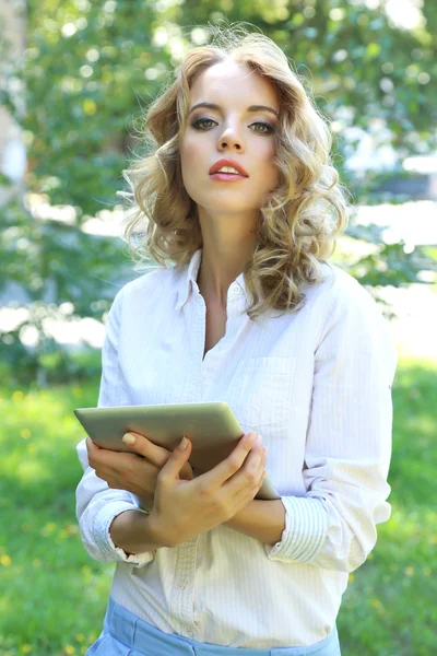 Beautiful young girl with tablet on city street — Stock Photo, Image