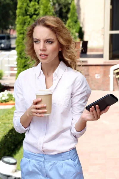 Businesswoman with mobile phone on city street — Stock Photo, Image