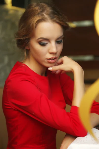 Hermosa joven sentada en la cafetería detrás del vidrio — Foto de Stock