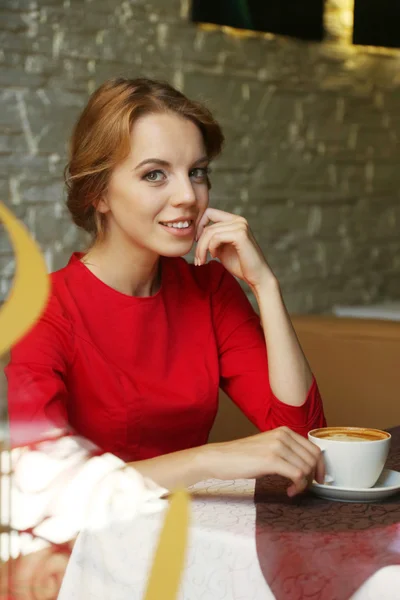 Hermosa joven sentada en la cafetería detrás del vidrio —  Fotos de Stock