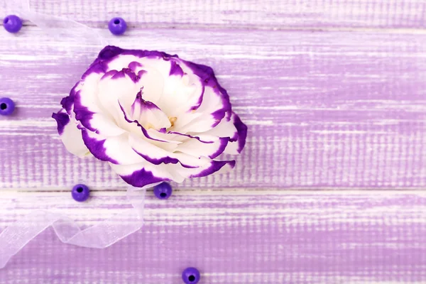 Vackra konstgjorda Eustomor på lila trä bakgrund — Stockfoto
