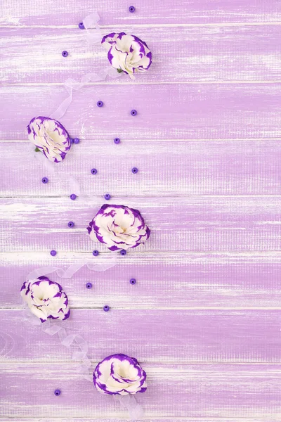 Bellissimi eustomi artificiali su sfondo di legno viola — Foto Stock