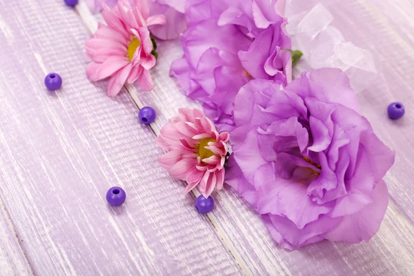 Krásné chryzantémy a umělé eustoma, květy fialové dřevěné pozadí — Stock fotografie