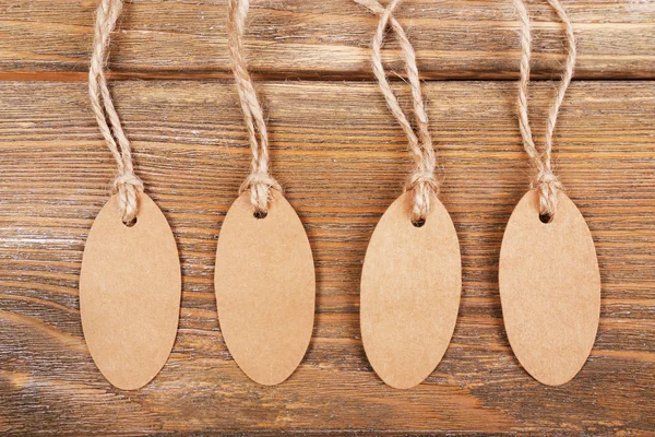 Empty tags on brown wooden background — Stock Photo, Image