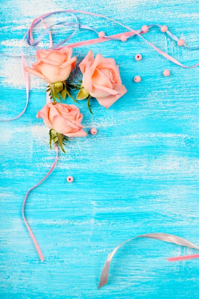 Beautiful roses on blue wooden background — Stock Photo, Image