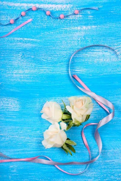 青い木製の背景に美しいバラの花 — ストック写真