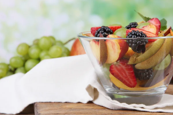 Ensalada de frutas frescas y sabrosas sobre mesa de madera, sobre fondo natural —  Fotos de Stock