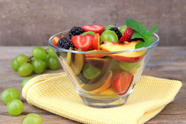 Frischer, schmackhafter Obstsalat auf Holztisch — Stockfoto