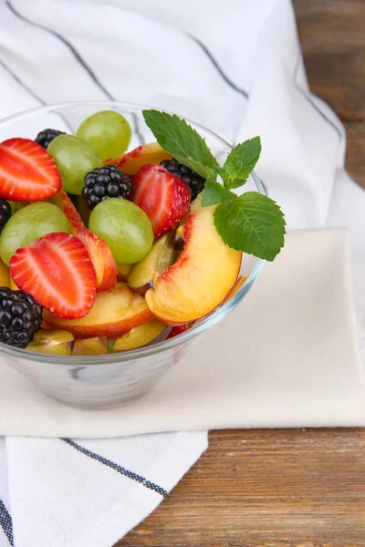 Fresh tasty fruit salad on wooden table — Stock Photo, Image