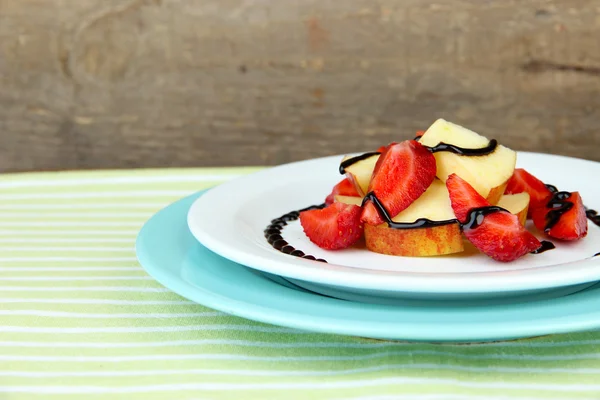 Fresh tasty fruit salad on table, on wooden background — Stock Photo, Image