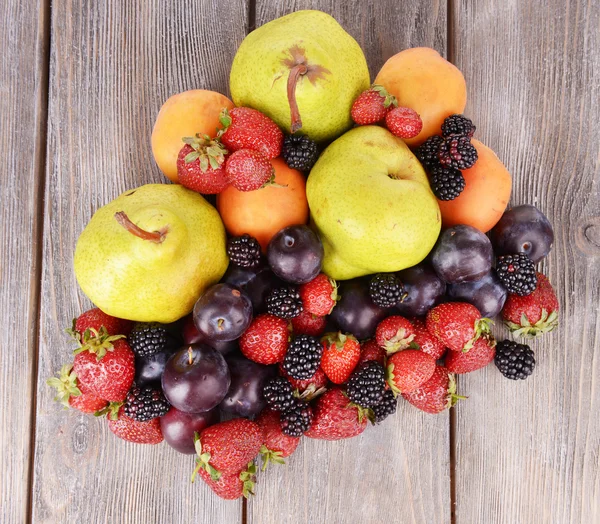 Frutas maduras y bayas sobre fondo de madera — Foto de Stock