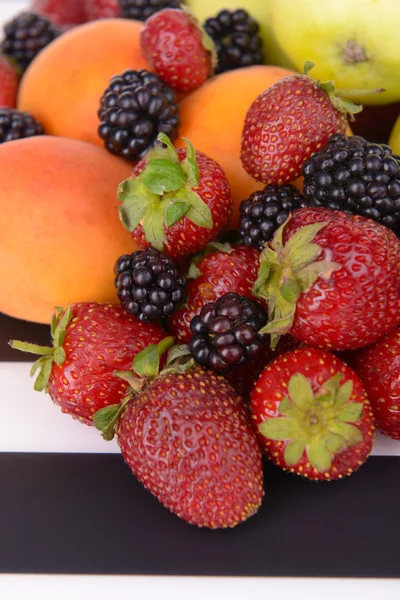 Frutas maduras e bagas em fundo listrado — Fotografia de Stock