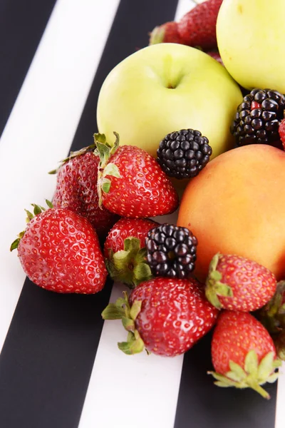 Frutas maduras y bayas sobre fondo rayado — Foto de Stock