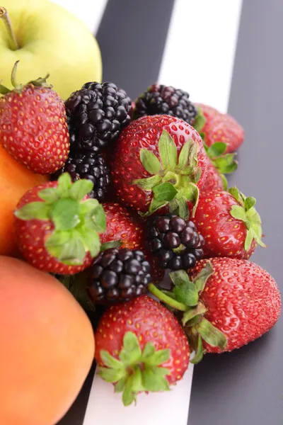 Frutas maduras e bagas em fundo listrado — Fotografia de Stock