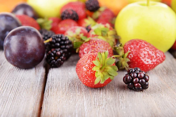 Frutas maduras e bagas em fundo de madeira — Fotografia de Stock