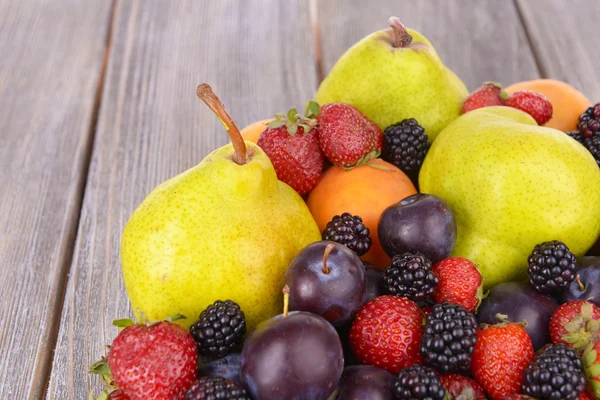 Frutas maduras y bayas sobre fondo de madera — Foto de Stock