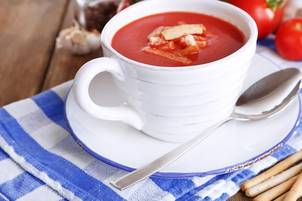 Вкусный томатный суп с гренками на деревянном столе — стоковое фото