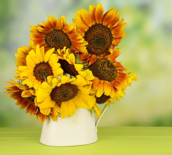 Hermosos girasoles en jarra en la mesa sobre fondo brillante — Foto de Stock