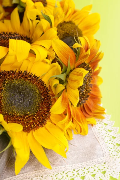 Beautiful sunflowers in pitcher on napkin on table close up — Stock Photo, Image