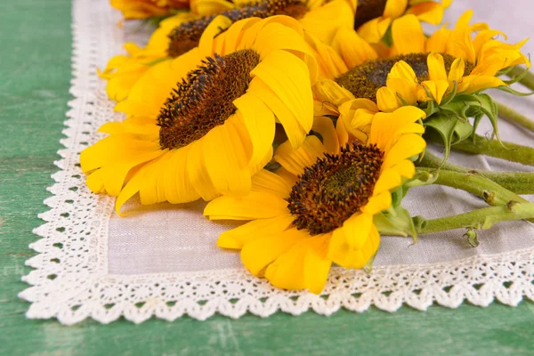 Schöne Sonnenblumen im Krug auf Serviette auf dem Tisch in Großaufnahme — Stockfoto