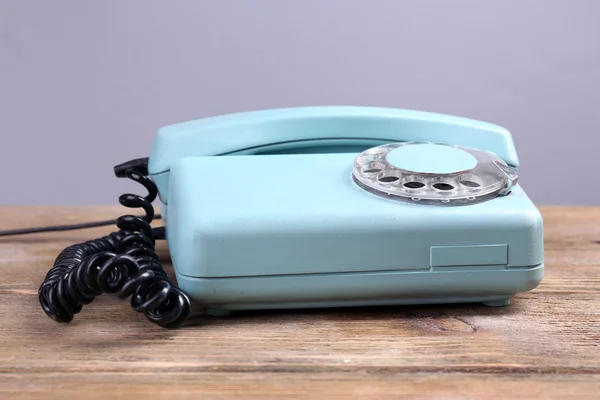 Retro türkiz telefon, fából készült tábla, színes háttérrel — Stock Fotó