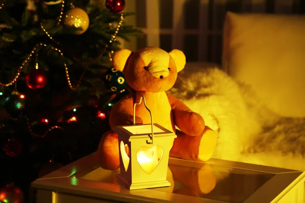 Teddybär im heimischen Interieur auf dekoriertem Weihnachtsbaum Hintergrund — Stockfoto