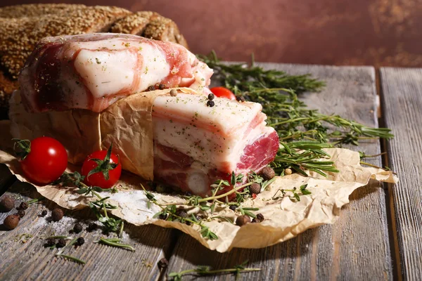 Bacon cru com especiarias e tomates na mesa de madeira — Fotografia de Stock