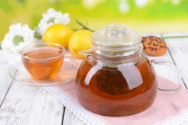 Theepot en kopje thee op tafel op lichte achtergrond — Stockfoto