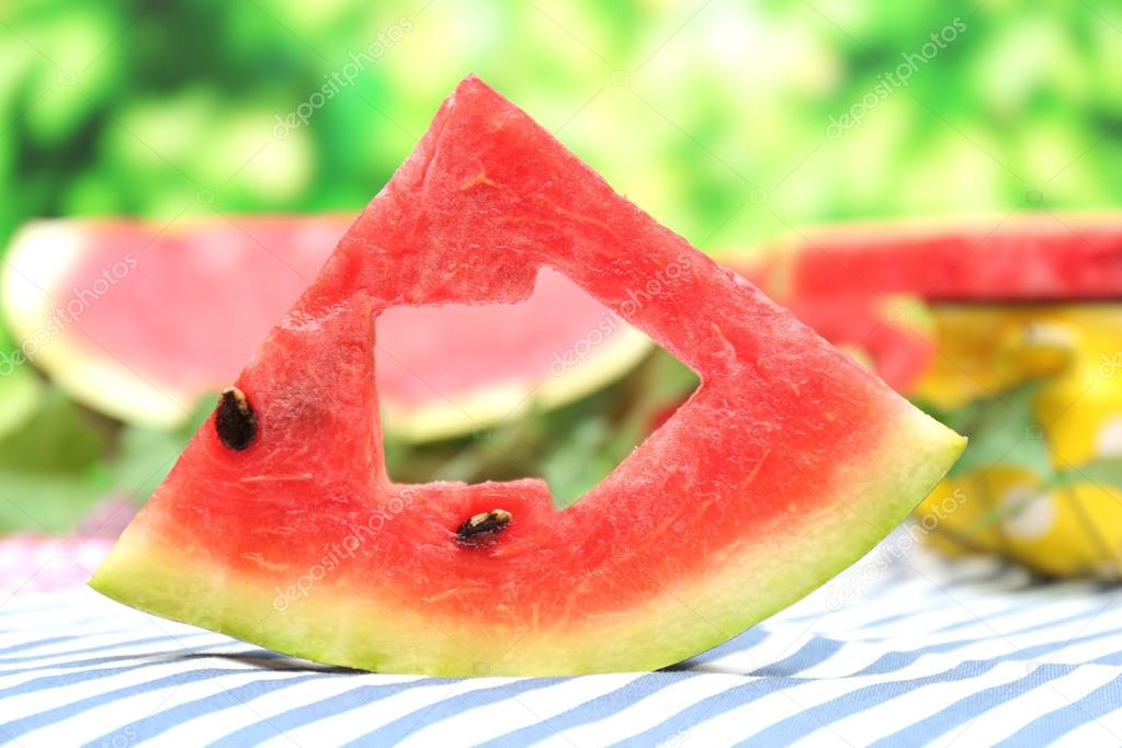 Fresh slices of watermelon on table, on nature background