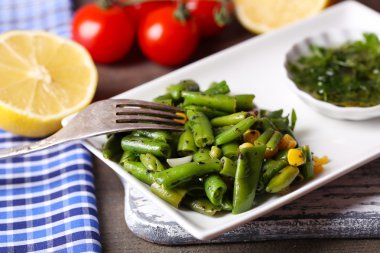 salata fasulye ve Mısır, plaka renk ahşap zemin üzerine sos ile