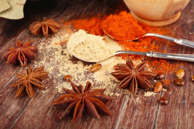 metal kaşık, farklı tam kahverengi ahşap zemin üzerinde ahşap kase yuvarlak ve defne yaprağı ile baharat