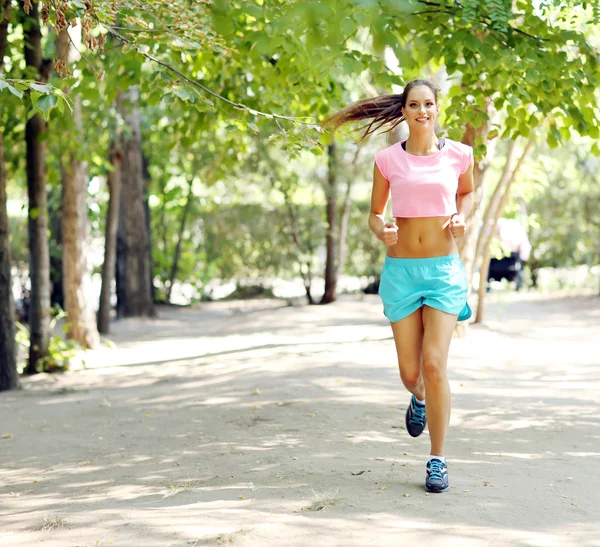 Mladá žena jogging v parku — Stock fotografie