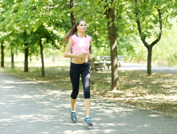 Junge Frau joggt im Park — Stockfoto