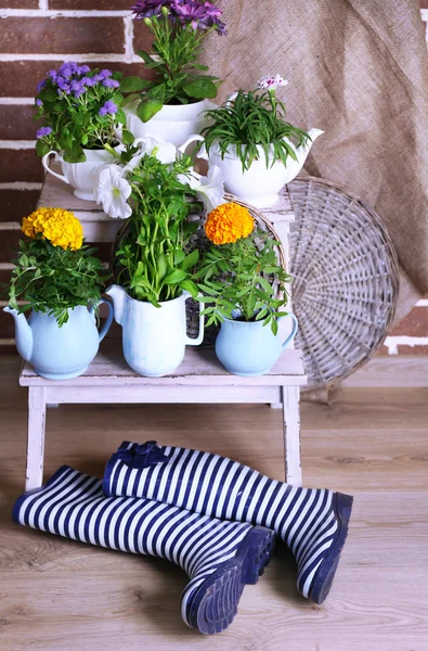Bloemen in decoratieve potten op houten ladder, op bakstenen achtergrond — Stockfoto