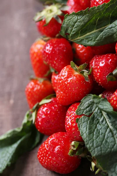 Reife süße Erdbeeren auf farbigem Holzhintergrund — Stockfoto
