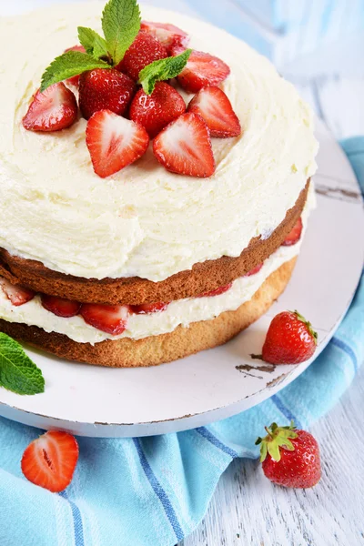 Delicious biscuit cake with strawberries on table close-up — Stock Photo, Image