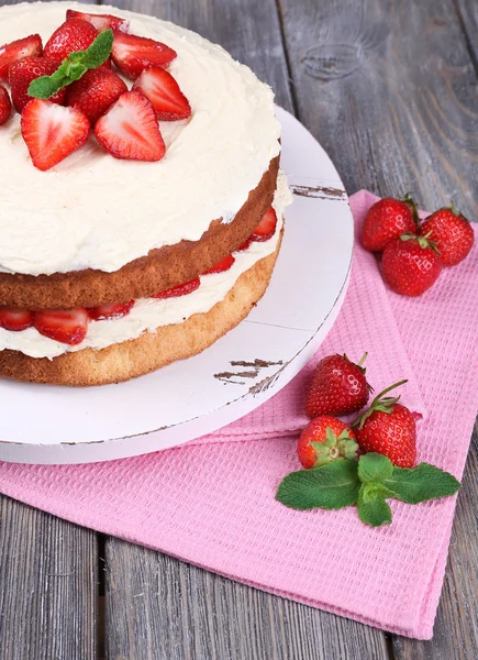 Heerlijke biscuit cake met aardbeien op tabel close-up — Stockfoto