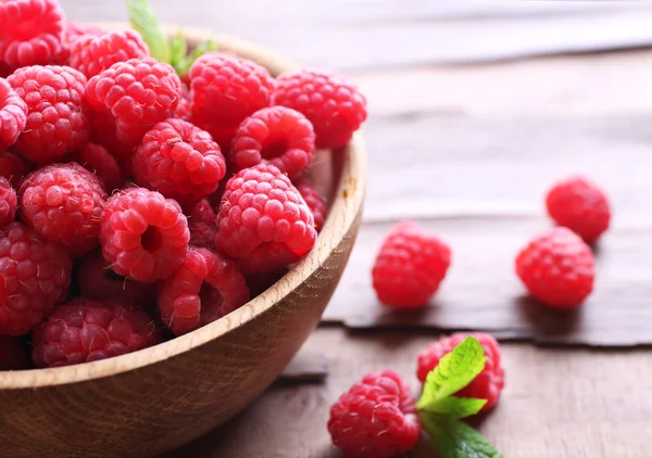 Ripe sweet raspberries in bowl on table close-up — Stock Photo, Image