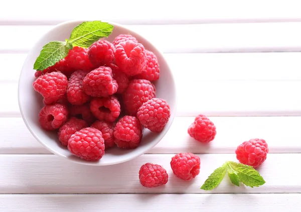 Ripe sweet raspberries in bowl on table close-up — Stock Photo, Image