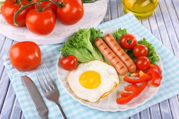 Huevo revuelto con verduras y salchichas servidas en plato sobre servilleta — Foto de Stock