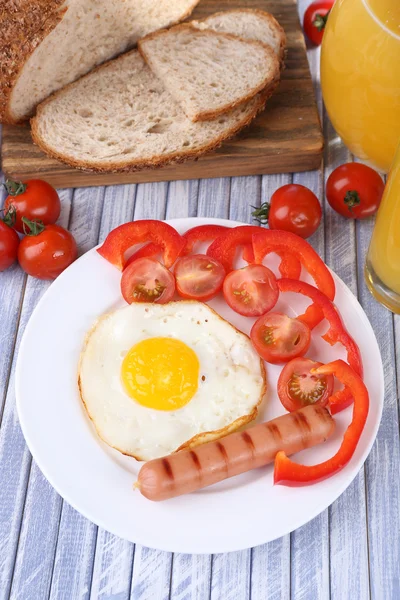 Uova strapazzate con pane, verdure e salsiccia servite in piatto su fondo di legno — Foto Stock