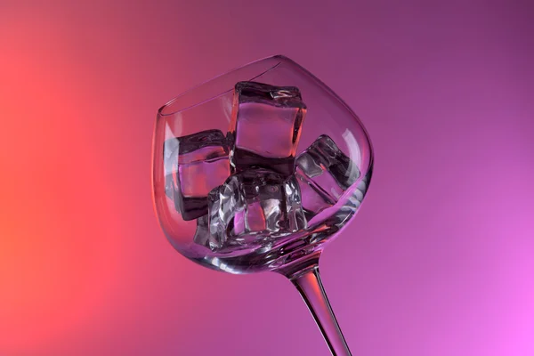 Glas med isbitar på färgbakgrund — Stockfoto