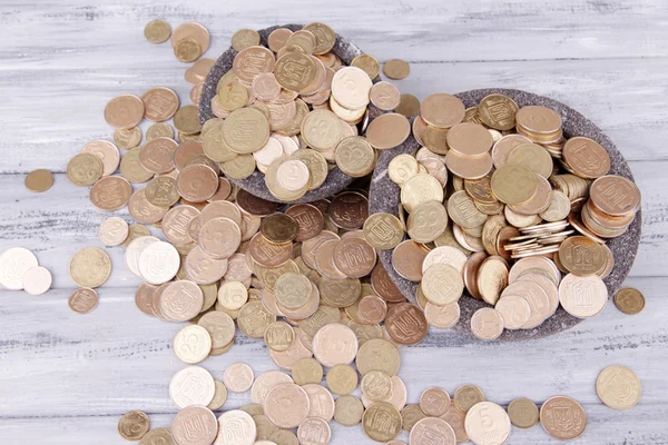 Black round plates full of Ukrainian coins on wooden table — Stock Photo, Image