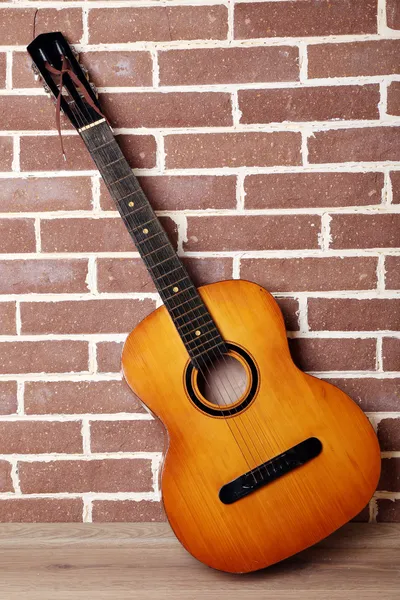 Gitara na podłodze na tle ściany Cegła — Zdjęcie stockowe
