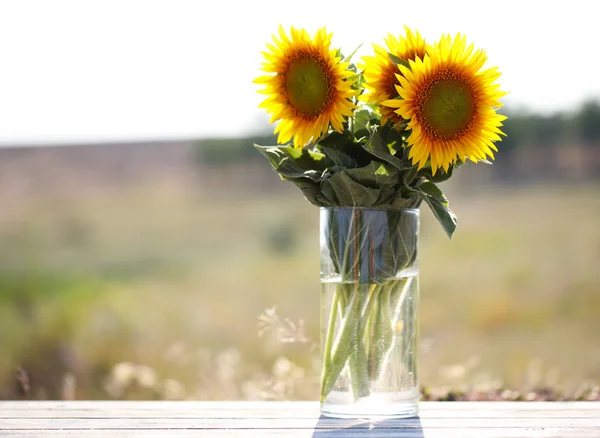 Mooie zonnebloemen op tafel op lichte achtergrond — Stockfoto