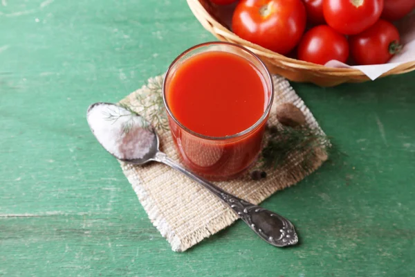 Jugo de tomate casero en vaso, especias y tomates frescos sobre fondo de madera — Foto de Stock