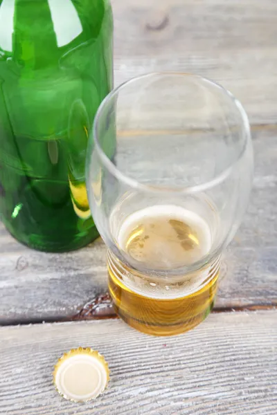 Láhve a sklenice s studený nápoj, na dřevěné pozadí — Stock fotografie